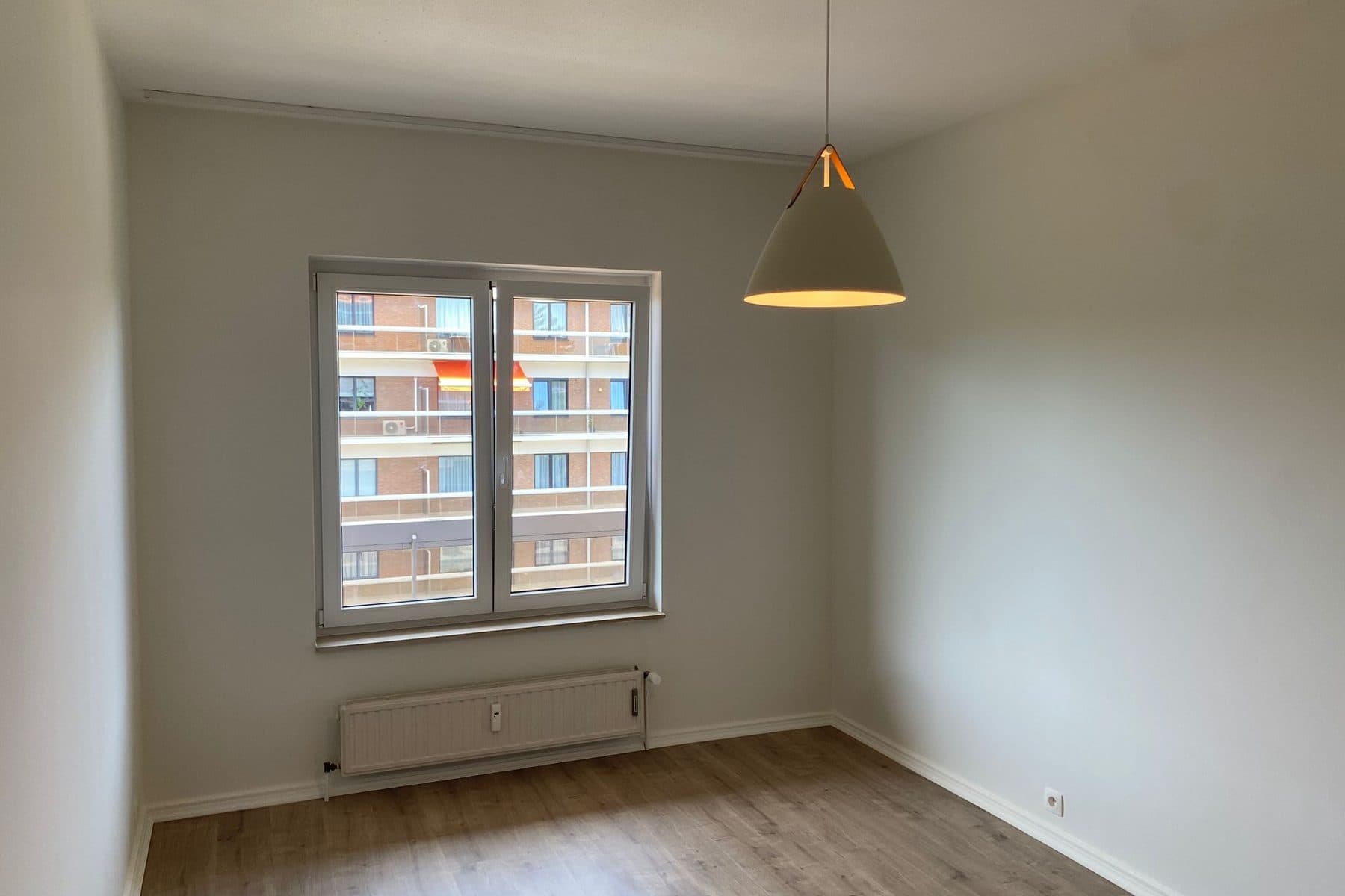 Chambre repeinte, fenêtre à deux vantaux, suspension et radiateur