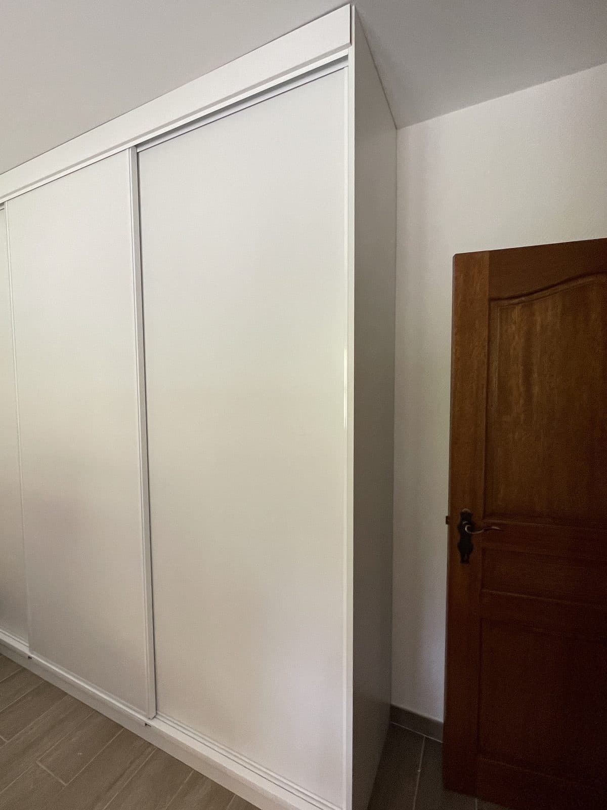 Placard blanc à portes coulissantes ajusté sous la pente