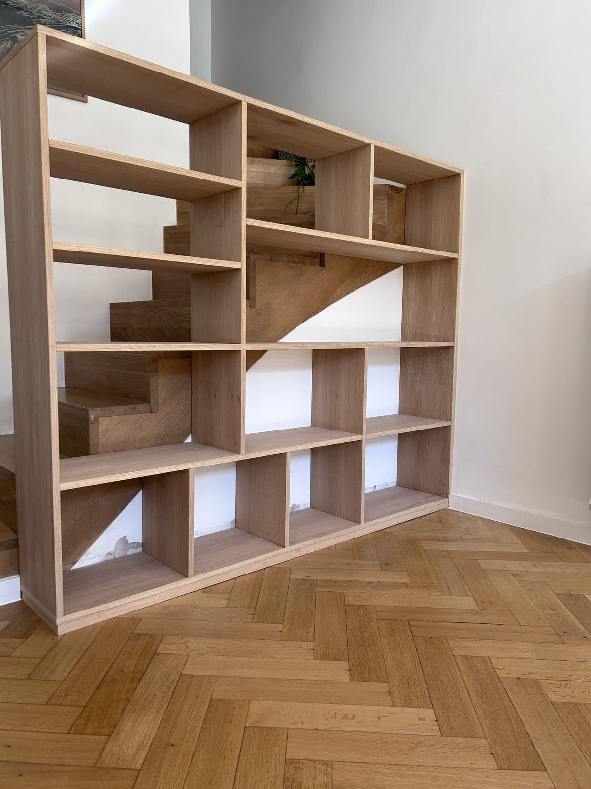Étagère ouverte en chêne devant un escalier en chêne