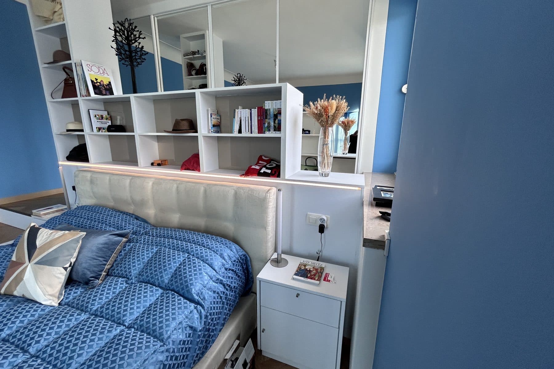 La même chambre, meublée : le lit devant la bibliothèque blanche à ligne lumineuse
