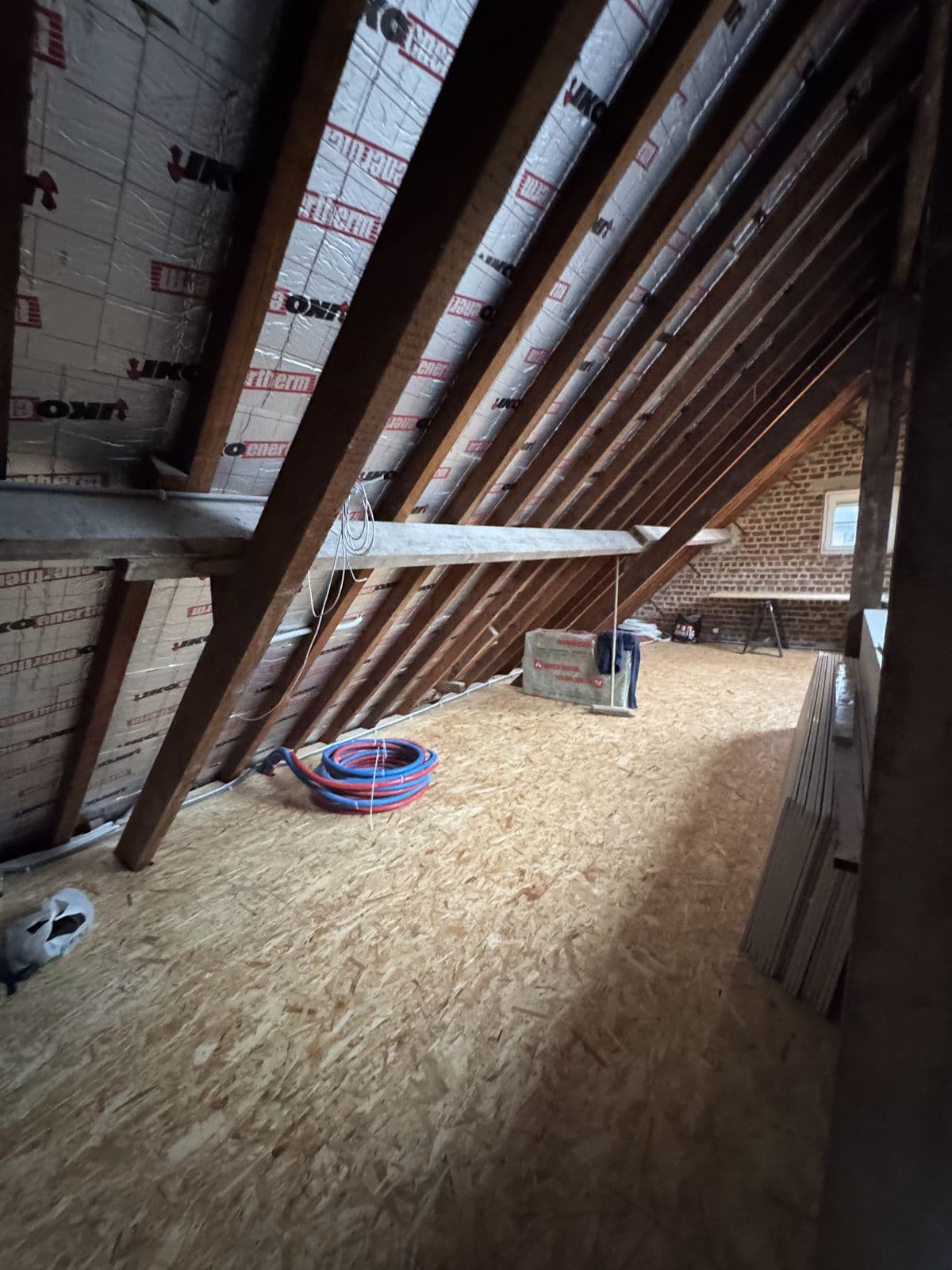 Le long rampant isolé, panneaux posés entre les chevrons, plancher en OSB