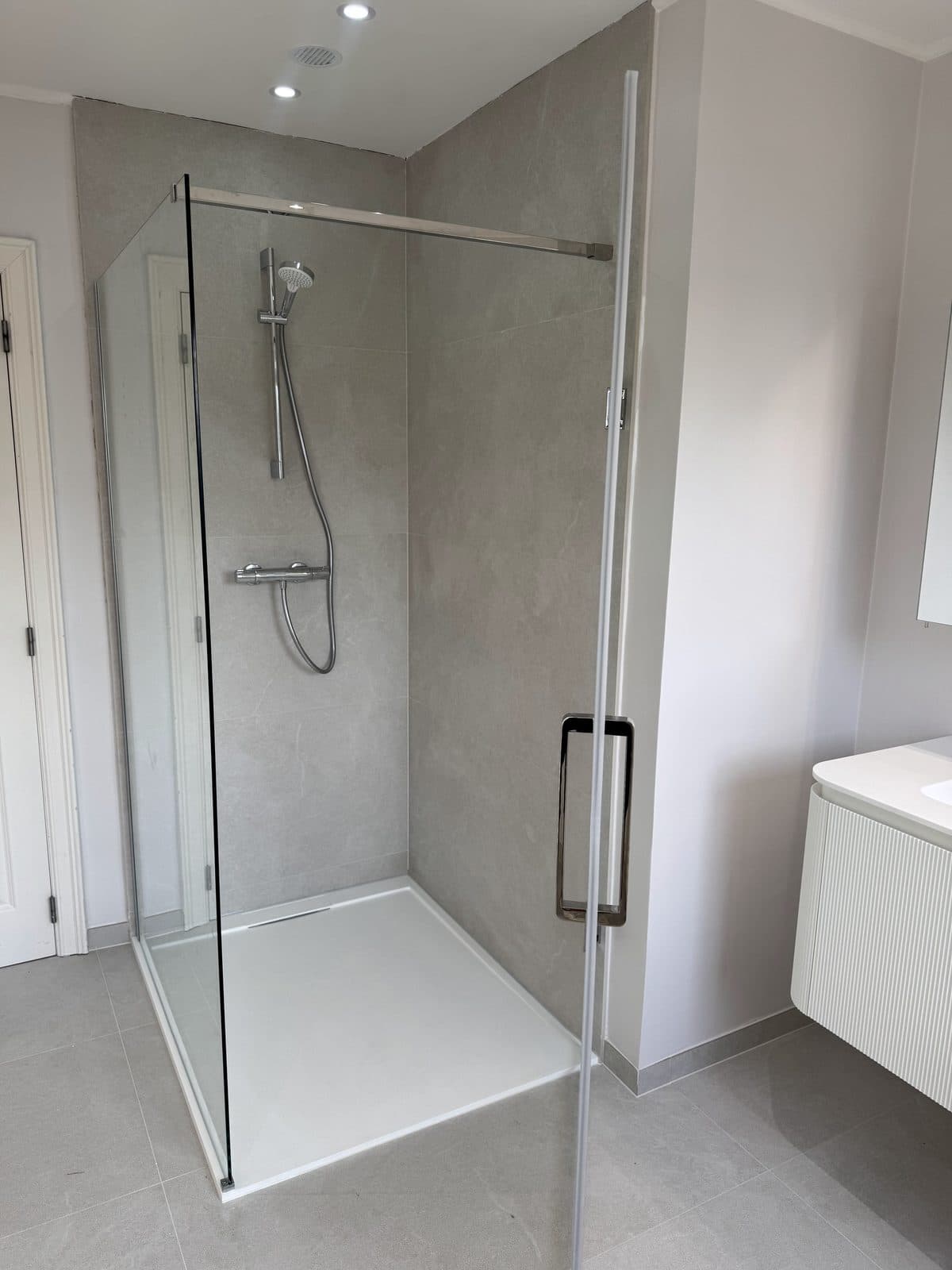 La cabine de douche vue de près, robinetterie chromée