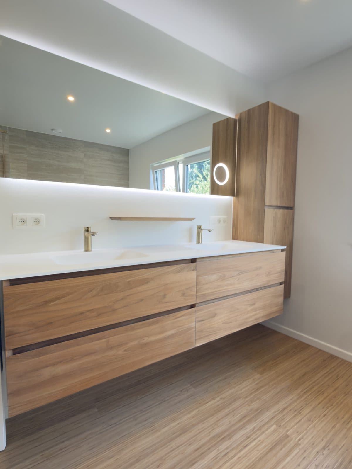 Meuble double vasque suspendu en bois, plan blanc, miroir rétroéclairé, colonne en bois et robinetterie en laiton
