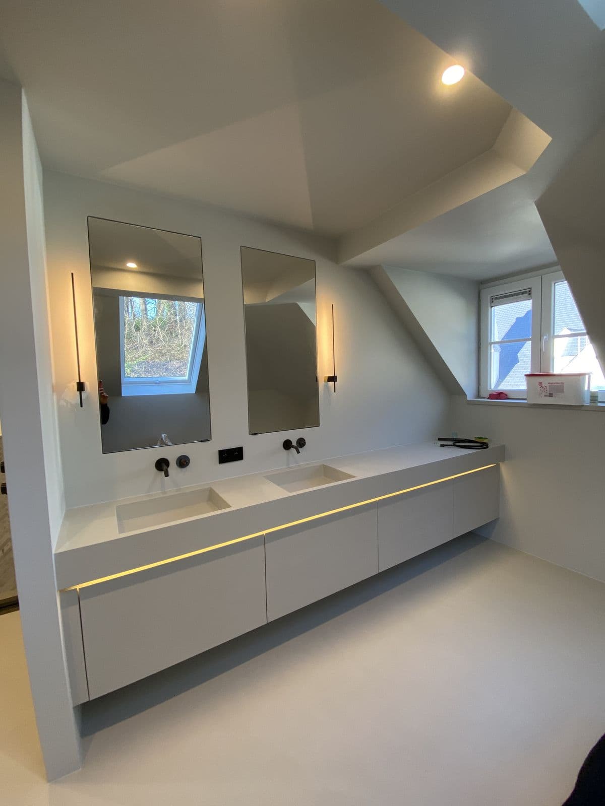 Long meuble double vasque suspendu, ruban lumineux, deux miroirs et robinetterie noire murale, sous la pente