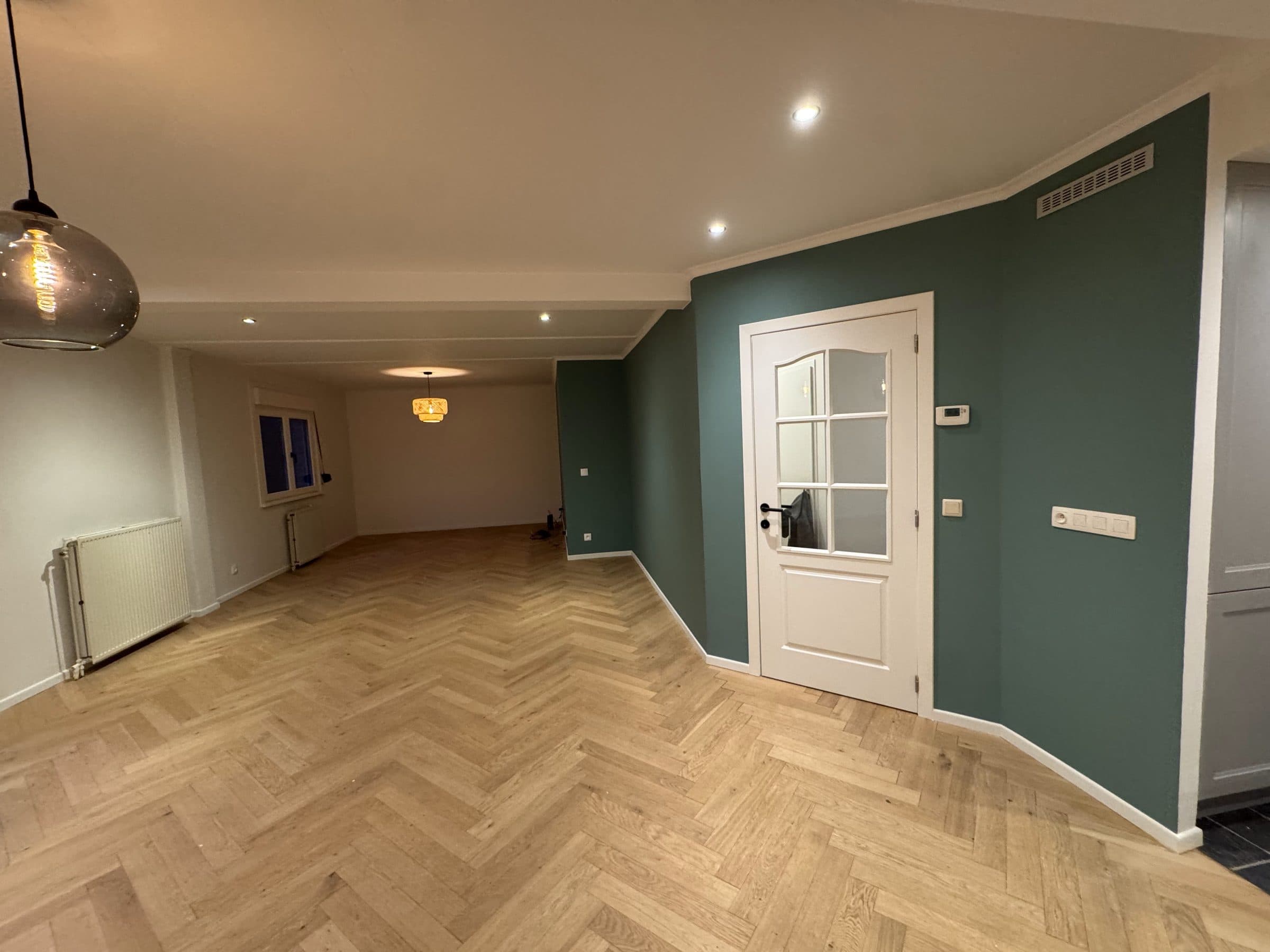 Un séjour rénové : mur vert d’aplomb, porte vitrée d’équerre, parquet à bâtons rompus de niveau.